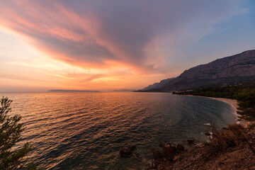 Sonnenuntergang an der Küste in Tučepi in Kroatien. Blick auf das Meer, die Wellen, die Insel Brač am Horizont