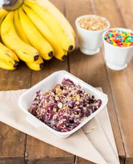 Brazilian Açai on a white Styrofoam box pot with granola on a wooden background and fruits at summer