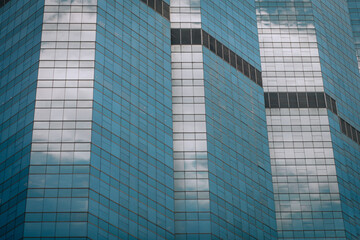 Obraz premium High-rise wide glass building with black windows in a row, backgroung