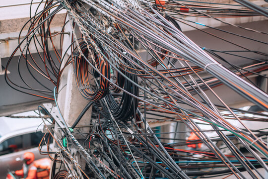 A huge number of multi-colored tangled wires on a pole, background, close up