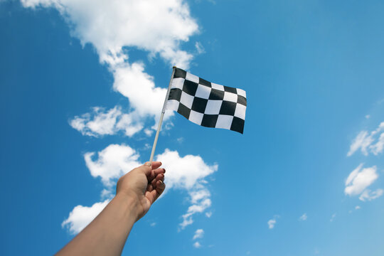 hand holding a checkered flag
