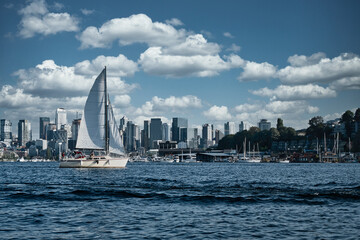 Naklejka premium 2020-08-13 A SAIL BOAT IN SOUTH LAKE UNION WITH THE SEATTLE CITY SKYLINE AND WHITE CLOUDS