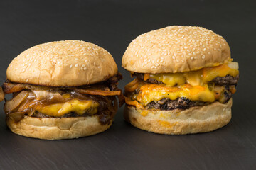 Close-up of tasty homemade gourmet hamburgers on wooden board with rustic background