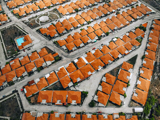 Top view of old european city with orange roofs. Lined up residential buildings with red tiled roofs