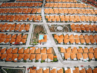 Top view of old european city with orange roofs. Lined up residential buildings with red tiled roofs