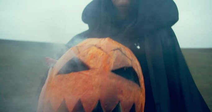 Smoke coming out of the carved pumpkin, witch is holding it, Halloween, 4k