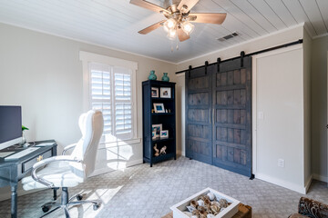 Home Office with custom barn doors, shelves, white