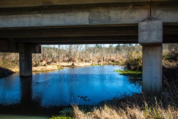 Naklejka premium A river stream under a bridge in the south