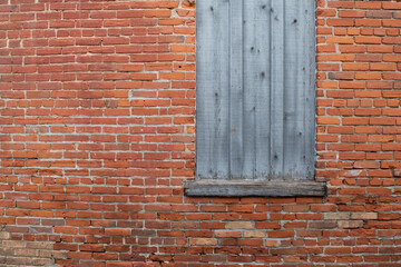 Weathered wooden window with brick wall
