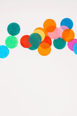 Colorful confetti on white background with copy space.