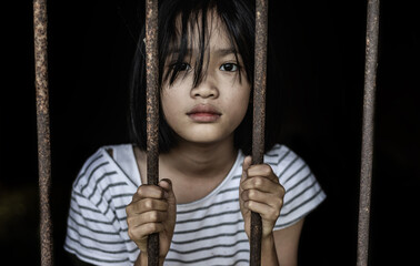 Human right day concept: little girl hold cage with eye sad and hopeless.