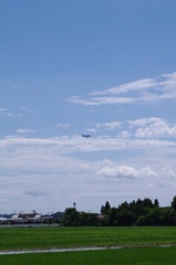 Fototapeta na wymiar 長閑な田園地帯の青空に浮かぶ飛行船