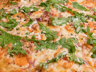 Obraz na płótnie Canvas Closeup photo of a cheese pizza topped with arugula leaves
