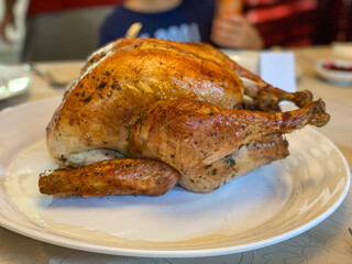 Above closeup photo of a roasted turkey on a white platter.