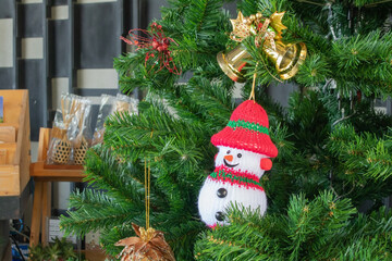 Winter Christmas Background Concept : Snow toy hang on green pine tree.