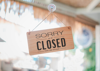 Closed Text in wooden signboard sorry please come back again on door of business shop.