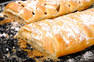 sweet homemade fresh baked goods. puff pastry pies with sweet filling on a baking sheet close-up