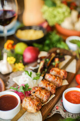 Muslim Ramadan iftar family dinner. Flat-lay of people feasting over table with Middle East food. Dates, dolma, kebab, flatbread, pide, borek, sweet, salad, top view. Ramazan fasting Turkish cuisine.
