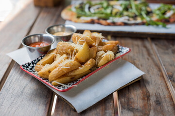 Potato wedges on wooden table with blurred background