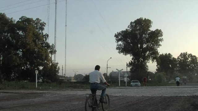 Man Riding a Bike Safely Crossing The Railroad Tracks during Sunrise, San Carlos Centro, Santa Fe province, Argentina.