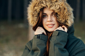 Woman in warm jacket outdoors fresh air close-up hood on her head