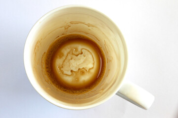 A white used dirty coffee cup.