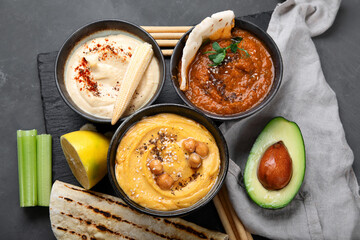 Different kinds of hummus dips with snacks