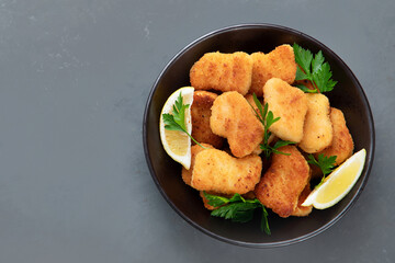 Crispy chicken nuggets on grey background.