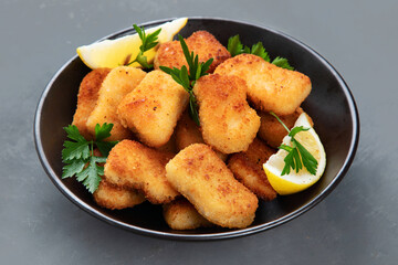 Crispy chicken nuggets on grey background.