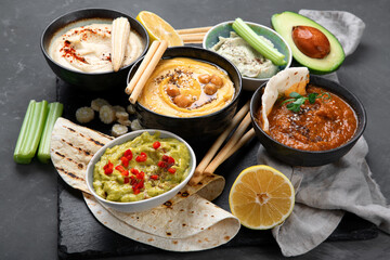 Different kinds of hummus dips with snacks
