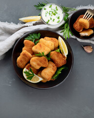 Crispy chicken nuggets on grey background.