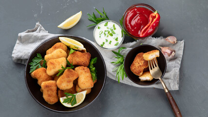 Crispy chicken nuggets on grey background.