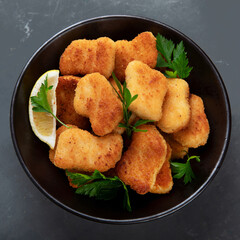 Crispy chicken nuggets on grey background.