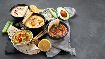 Different kinds of hummus dips with snacks