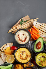 Different kinds of hummus dips with snacks