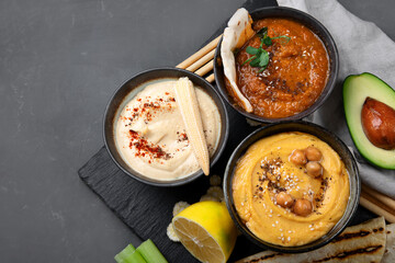 Different kinds of hummus dips with snacks