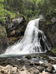 the most beautiful waterfall among the trees in the forest in austria