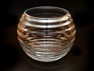 Glass fluted transparent vase close up on black background