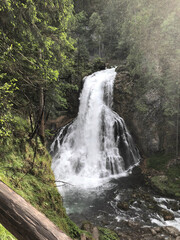 the most beautiful waterfall among the trees in the forest in austria