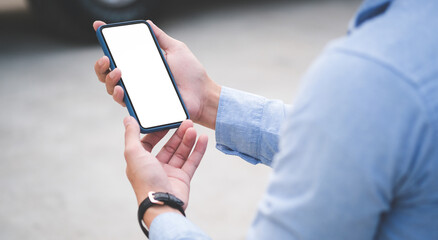 Cropped shot of businessman holding mobile phone with blank screen for your text message or information content.