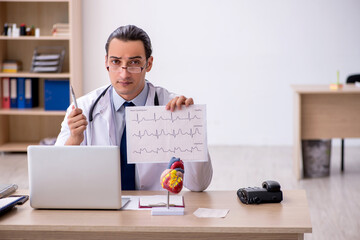 Young male doctor cardiologist looking electrocardiogram