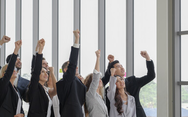Multi ethnic diversity business people standing in a row, holding fists up and looking up together with smiley face at office conference room. Side view, selective focus. - Powered by Adobe