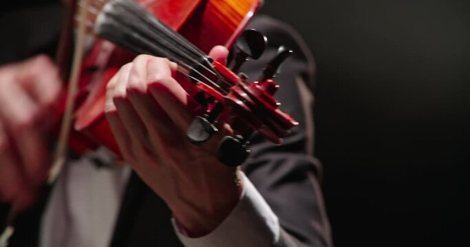 Professional violinist playing the violin on a black background, close-up, 4k video.