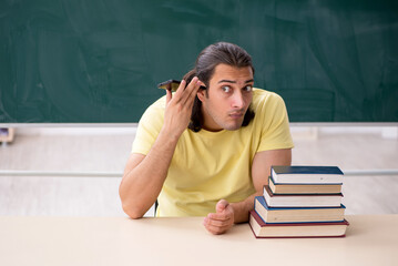 Young male student preparing for exams in the classroom