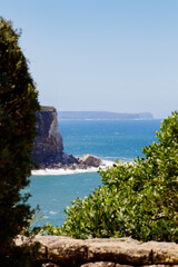 Cliff near Whale Beach detail from Careel Lookout. Blue ocean and waves smashing on rocks.