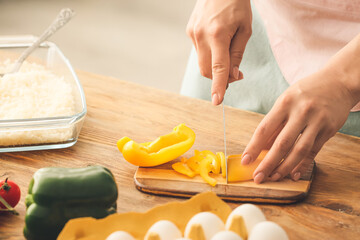 Woman cooking rice casserole on table, closeup