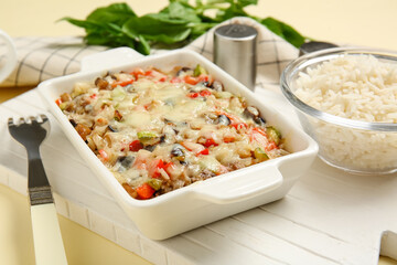 Baking dish with tasty rice casserole on table