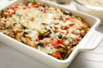 Baking dish with tasty rice casserole on table, closeup