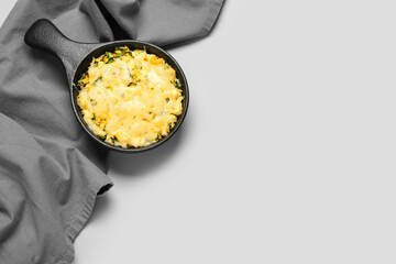Baking dish with tasty rice casserole on light background