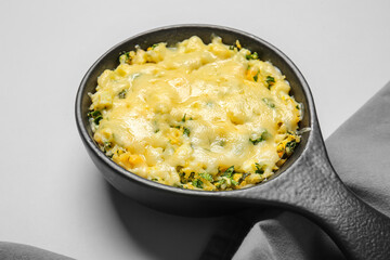 Baking dish with tasty rice casserole on light background